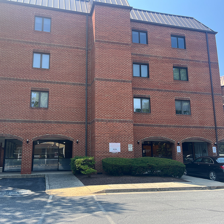 The image shows a multi-story brick building with a sign that reads  175  on the front, indicating it s an apartment complex. There are multiple windows and a parking lot visible in the photo.