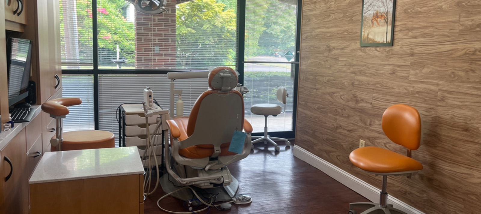 The image shows a dental office interior with dental chairs, equipment, and a reception area.