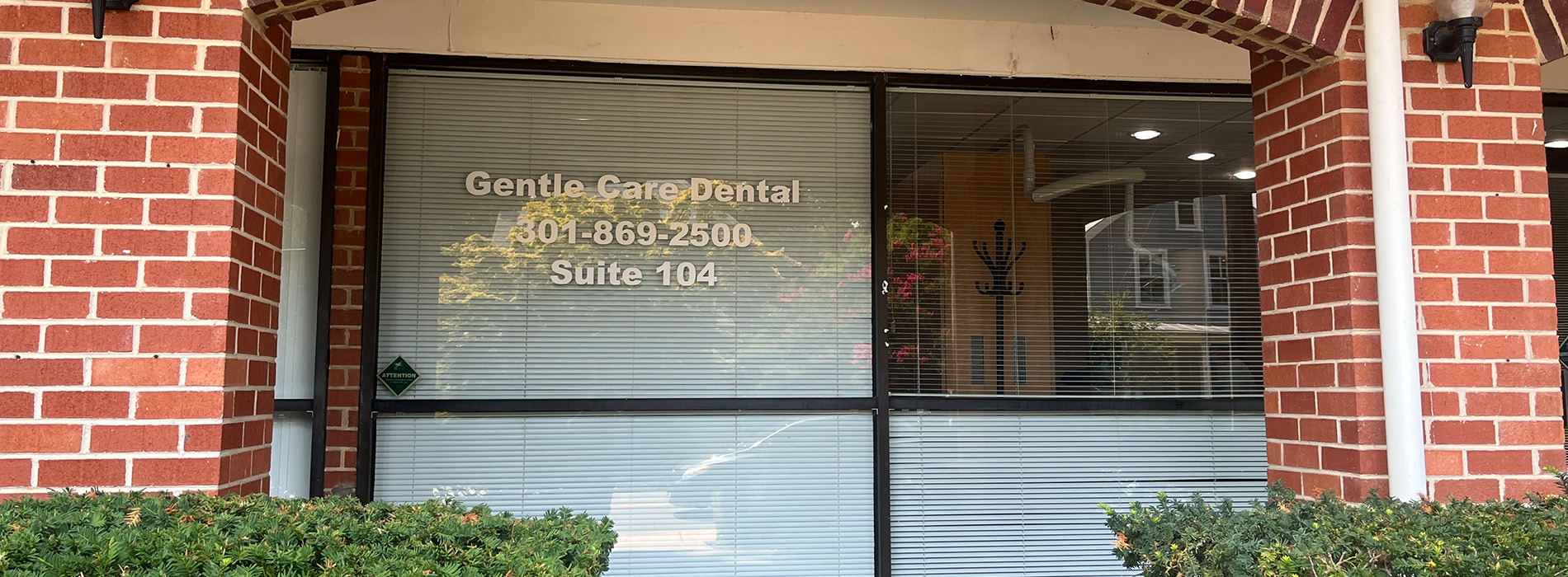 The image shows a storefront with a sign that reads  Gentle Care Dental Clinic  and a phone number below it.