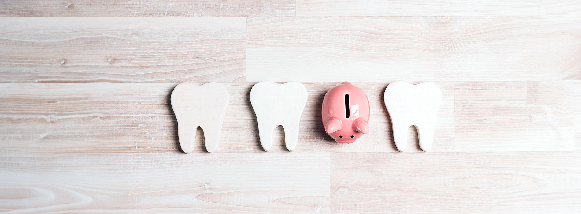 The image shows a collection of wooden cutouts shaped like various animals, including a pig, positioned on a light-colored surface with a blurred background.