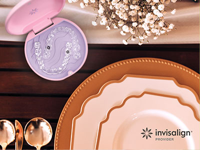 A promotional image showcasing a set of dinnerware, including plates and a box with dental impression trays, against a backdrop of a dining table and decorative items.