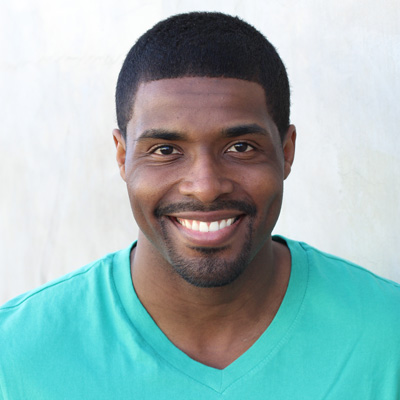 An elderly couple sharing a warm embrace, smiling at the camera.