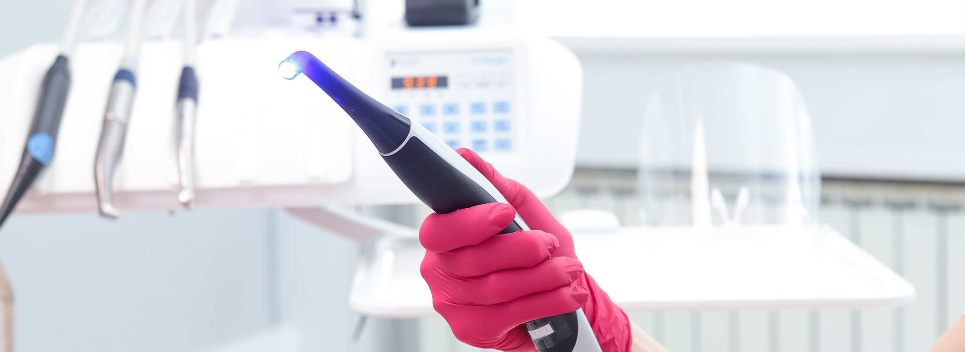 A person holding a blue device, possibly a medical or dental instrument, with a focus on their hands and the device.