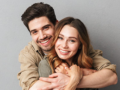 A man and a woman are embracing each other in a warm, affectionate pose.